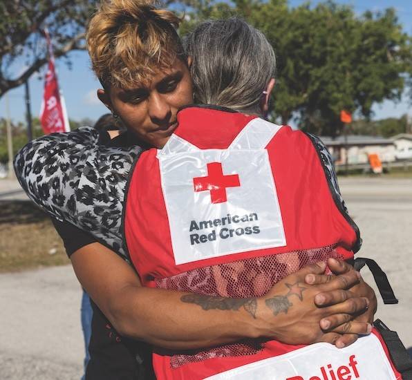 Red Cross volunteer hugging client.
